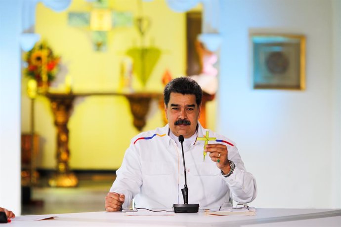 HANDOUT - 28 March 2021, Venezuela, Caracas: Nicolas Maduro, president of Venezuela, holds a cross during a press conference. Maduro has offered to swap oil for COVID-19 vaccines in view of rapidly rising coronavirus numbers as well as US sanctions agai