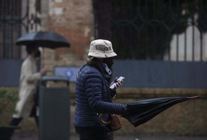 Archivo - Peatones con paraguas durante un día lluvioso y con rachas de viento en la provincia. En Sevilla (Andalucía, España), a 09 de febrero de 2021.