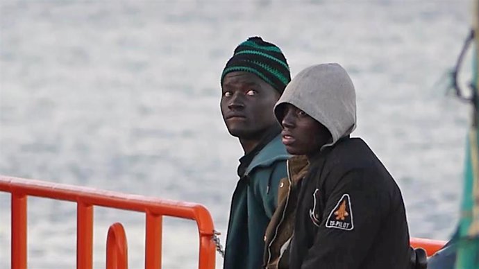 Archivo - Dos jóvenes migrantes bajan de un barco de la Cruz Roja en el puerto de Arguineguín (Gran Canaria).