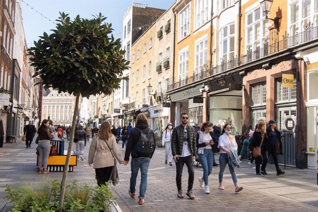 18 April 2021, United Kingdom, London: People take a walk at South Molton Street on the first weekend since lockdown restrictions were eased earlier this week. Photo: Matt Crossick/PA Wire/dpa
