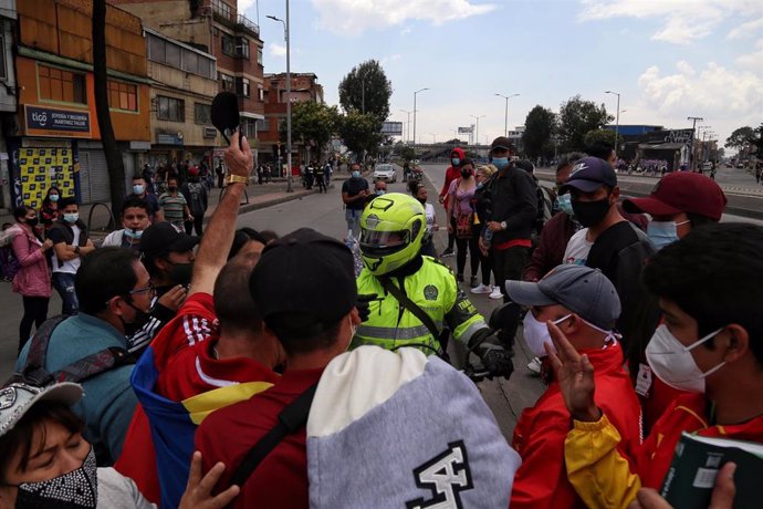 Un grupo de manifestantes se enfrenta con un motociclista durante una manifestación contra las restricciones impuestas para frenar la propagación de la pandemia de coronavirus en Bogotá.