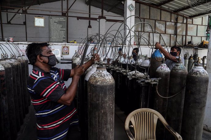 21 April 2021, India, New Delhi: Workers refill medical oxygen cylinders at a charging station during the second wave of the Covid-19 pandemic. Photo: Naveen Sharma/SOPA Images via ZUMA Wire/dpa