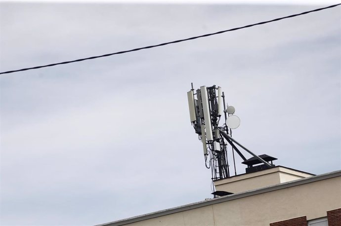 Archivo - Imagen de una antena de telefonía en el tejado de una casa en la ciudad de Madrid.