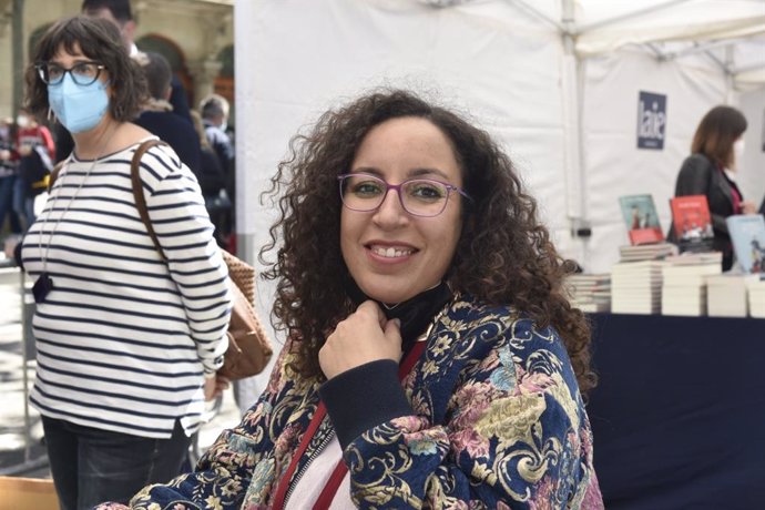 La premio Nadal Najat El Hachmi firma libros en una parada de Barcelona durante la Diada de Sant Jordi de 2021, adaptada a las medidas sanitarias por la pandemia del coronavirus.
