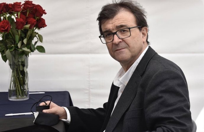 El escritor Javier Cercas firma libros en la Diada de Sant Jordi de 2021, en un recinto perimetrado por la pandemia del Covid-19.