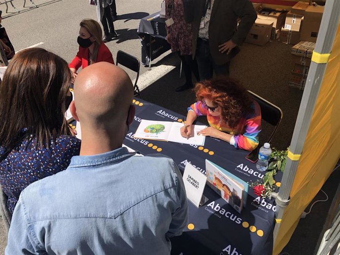 Dos padres esperan a que la cantante Dmaris Gelabert firme un ejemplar de su último libro 'Els dies de la Setmana', a su hijo, este 23 de abril de 2021 en Barcelona.