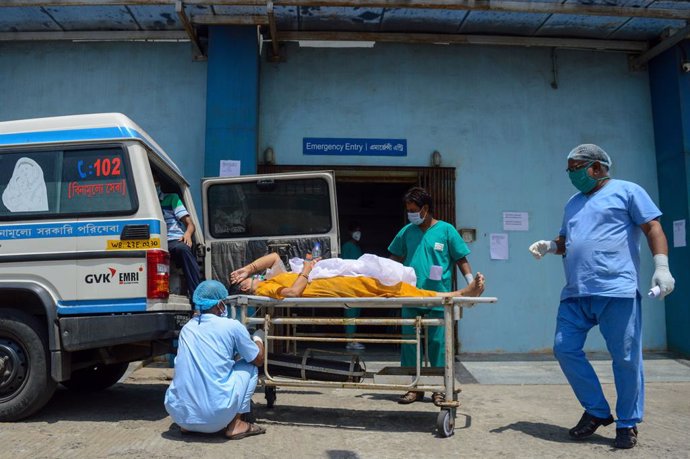 23 April 2021, India, Kolkata: Medics transport a patient suffering from coronavirus complications into a critical care unit at a Kolkata hospital. Photo: Debarchan Chatterjee/ZUMA Wire/dpa