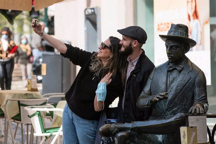 Una pareja posa junto a la estatua del poeta Fernando Pessoa, en el centro de Lisboa.