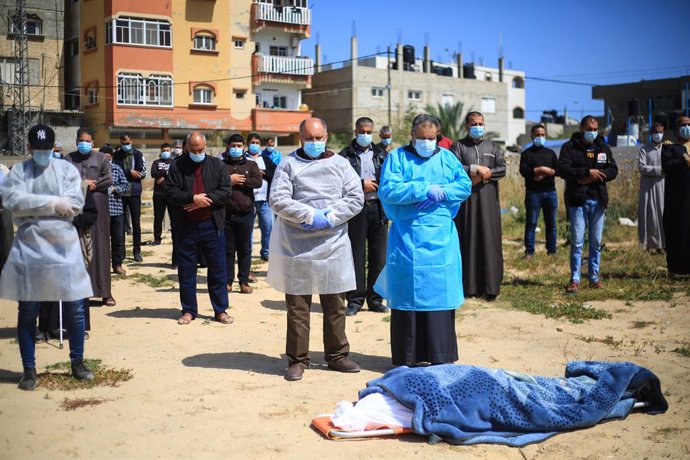 23 April 2021, Palestinian Territories, Deir al Balah: Palestinians perform a funeral ceremony for a woman who died of coronavirus in a cemetery in Deir Al-Balah city. Photo: Mahmoud Khattab/Quds Net News via ZUMA Wire/dpa