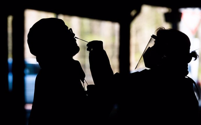 16 April 2021, Lower Saxony, Hanover: A health worker takes a swab from a man for the coronavirus test at the Testzentrum am Zoo. The Robert Koch Institute (RKI) continues to report rising levels of coronavirus infections in Germany. Photo: Julian Strat