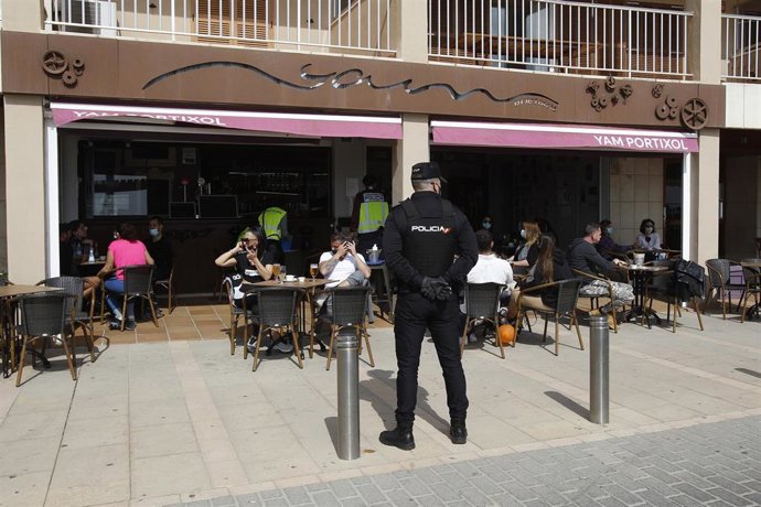 Archivo - Un agente de la Policía Nacional durante un control a una terraza. Archivo.