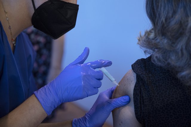 Una sanitaria vacuna a una mujer en la primera jornada de vacunación ante la Covid-19 en el Estadio de La Cartuja de Sevilla, (Andalucía, España), a 22 de abril de 2021.