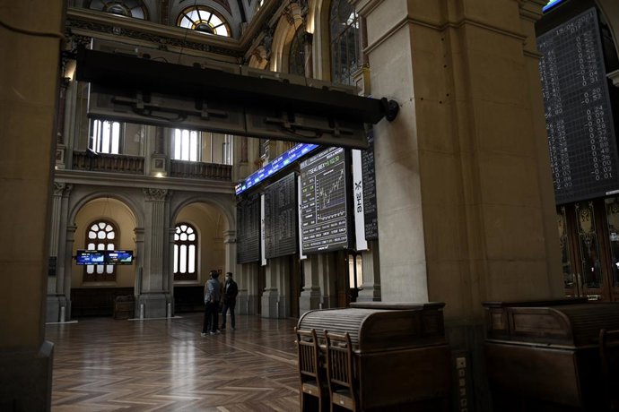 Un grupo de personas realiza una fotografía a los valores del Ibex 35 en el Palacio de la Bolsa, a 19 de abril de 2021, en Madrid, (España). 