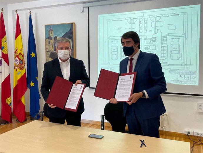 El consejero de Fomento y Medio Ambiente, Juan Carlos Suárez-Quiñones, y el alcalde de Carracedelo, Raúl Valcarce (d), firman el convenio de colaboración entre ambas instituciones.