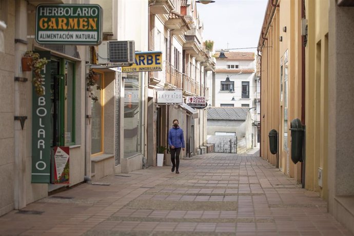 Una mujer camina por una calle de O Grove, el día en que entra en vigor el cierre perimetral del municipio, a 8 de abril de 2021