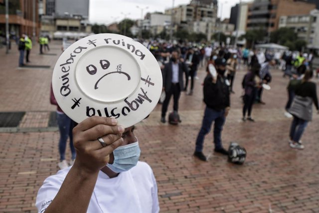 26 April 2021, Colombia, Bogota: A man holds a plate with words reads "Bankruptcy - Ruin", during a protest by restaurant and bar workers to demand support for the sector during the Coronavirus pandemic. Photo: Álvaro Tavera/colprensa/dpa