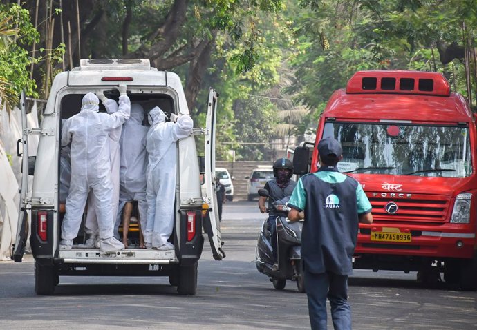 Trabajadores sanitarios trasladan a un paciente de coronavirus en la capital de India, Nueva Delhi