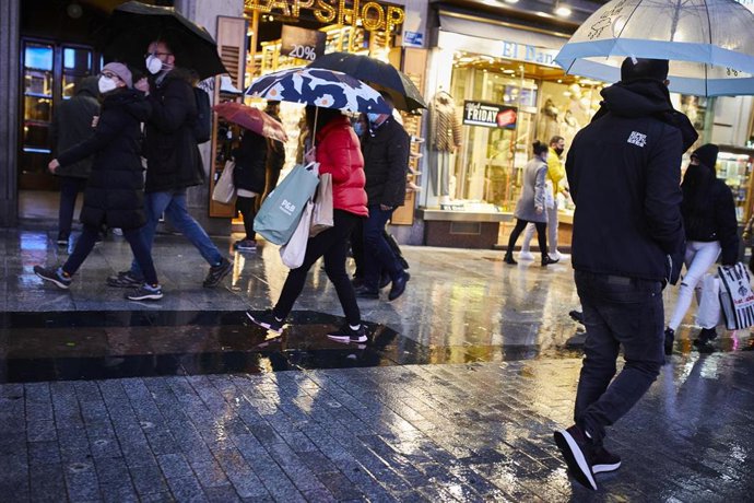Archivo - Transeúntes caminan cerca de una zona comercial en la calle de Preciados, en Madrid 