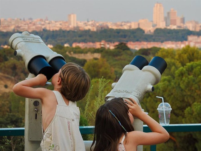 Archivo - Panorámica de la ciudad de Madrid vista por dos niños a través de unos binoculares