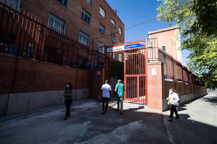 Archivo - Varias personas llegan para realizarse un test de coronavirus en el IES Ramiro de Maeztu, en Madrid