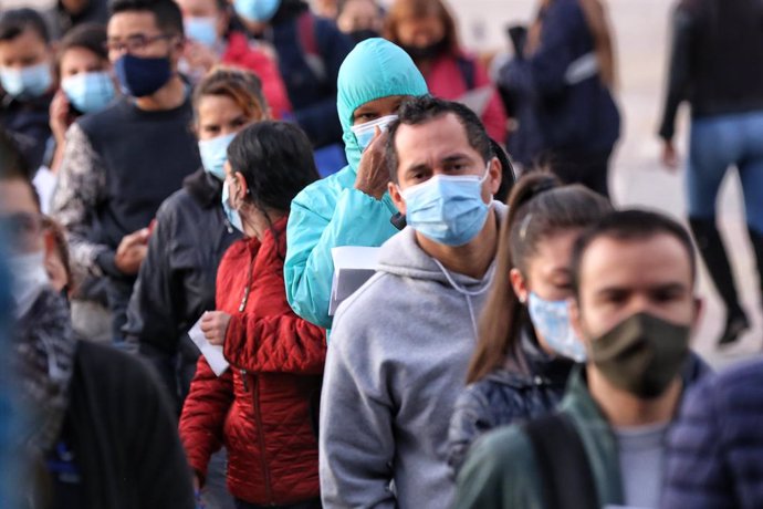 23 April 2021, Colombia, Bogota: People wearing masks queue in front of a checkpoint to access public transport on the first day of the third quarantine of April. Photo: Camila Díaz/colprensa/dpa