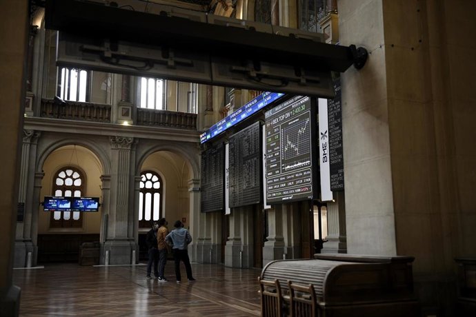 Un grupo de personas realiza una fotografía a los valores del Ibex 35 en el Palacio de la Bolsa, a 19 de abril de 2021, en Madrid, (España). Este lunes está marcado por una subida del Ibex del 0,2%, lo que ha llevado al selectivo a situarse en los 8.630