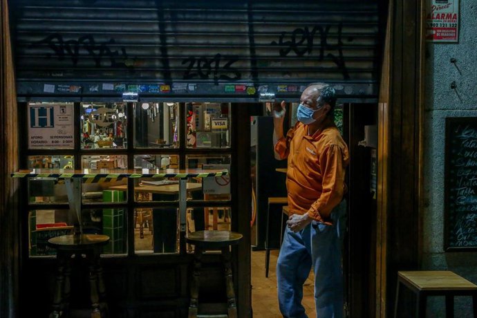 Archivo - Un hombre cierra su restaurante el día en el que se adelanta el cierre de hostelería a las 22.00h, en Madrid (España), a 18 de enero de 2021. 