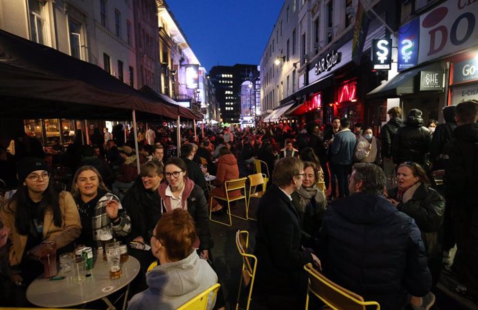 12 April 2021, United Kingdom, London: People crowd at the outdoor areas at of pubs in the Soho district, as Corona lockdown restriction eased in London. Photo: Jonathan Brady/PA Wire/dpa