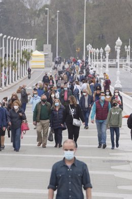 Varias personas caminan por el Paseo Marítimo de Gijón durante el primer día del puente de Semana Santa, en Gijón, Asturias (España), a 1 de abril de 2021. 
