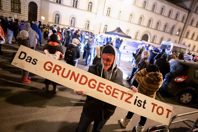 Archivo - 24 January 2021, Bavaria, Munich: A participant holds a sign in front of the Bavarian Constitutional Court during a demonstration organized by the Querdenken movement. Photo: Matthias Balk/dpa