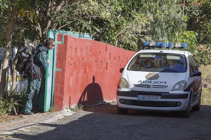 Un agente del GEAS de la Guardia Civil y un vehículo de la Policía Nacional en la zona donde se busca alguna pista de la desaparecida Juana Ramos, en una finca del camino Hoya Olivares, en el municipio de Arucas