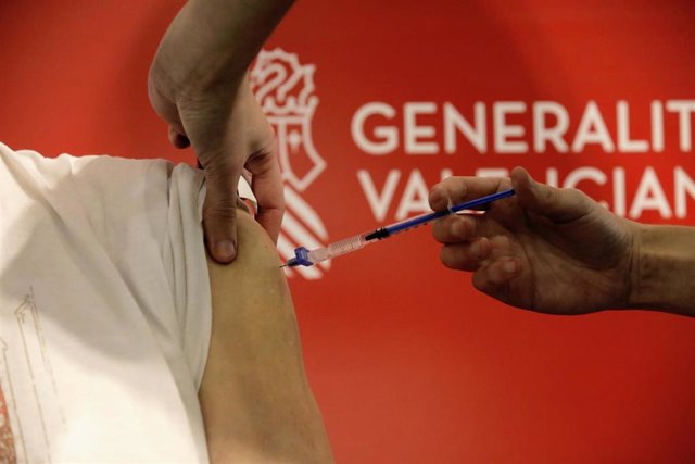 Una sanitaria vacuna a un hombre en el primer día de la vacunación masiva en Alicante