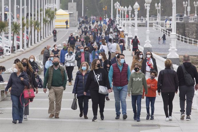 Varias personas caminan por el Paseo Marítimo de Gijón.