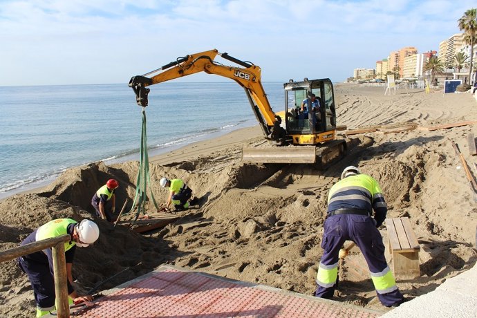 Una excavadora y operarios del Ayuntamiento de Fuengirola realizan labores en las playas tras los últimos temporales.