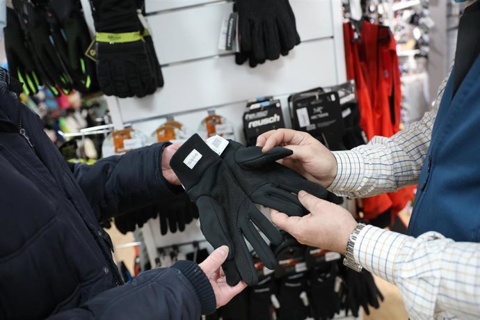 Archivo - Un trabajador de una tienda con unos guantes