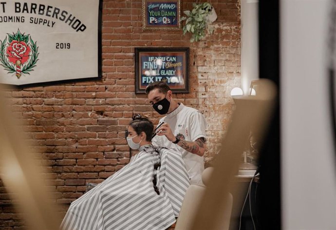 Un trabajador de una peluquería en su jornada laboral