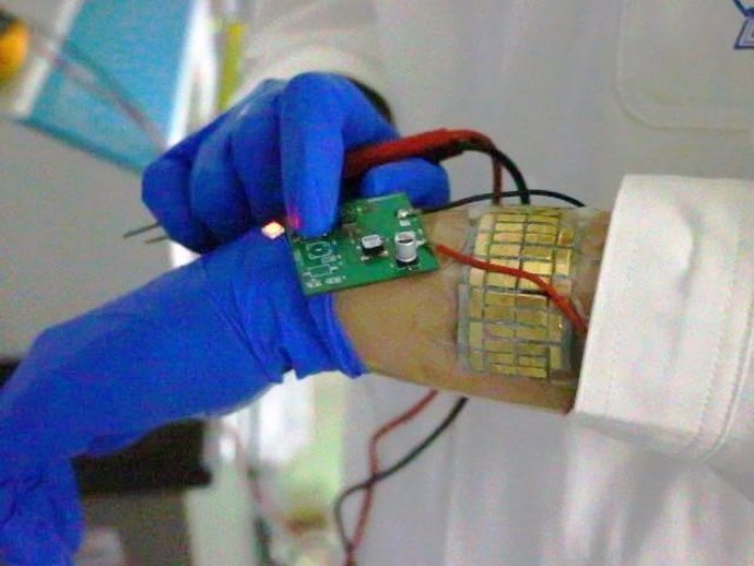 Esta imagen muestra a una persona usando el sistema eléctrico autoalimentado compuesto por una banda TEG y un LED.
