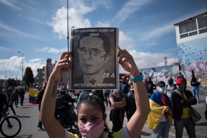 Una joven muestra un retrato contra el expresidente Álvaro Uribe durante las movilizaciones en contra de la reforma tributaria del Gobierno colombiano de Iván Duque.
