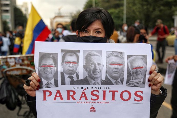 29 April 2021, Colombia, Bogota: A protester holds a placard says 'Parasites - No to Tax Reform' during a demonstration against the tax reform bill proposed by the government. Photo: Camila Díaz/colprensa/dpa