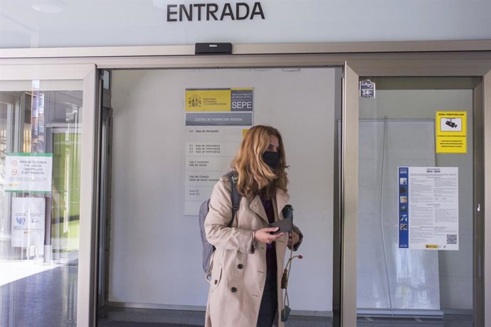 Una mujer entra por la puerta de una oficina del SEPE el día en el que se han conocido los datos de paro de marzo, a 6 de abril de 2021, en Madrid (España). El número de parados registrados en las oficinas de los servicios públicos de empleo (antiguo In