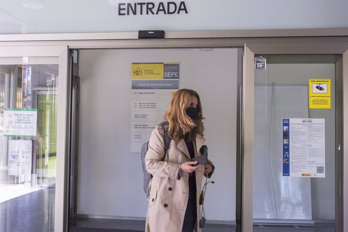 Una mujer entra por la puerta de una oficina del SEPE el día en el que se han conocido los datos de paro de marzo, a 6 de abril de 2021, en Madrid (España). El número de parados registrados en las oficinas de los servicios públicos de empleo (antiguo In