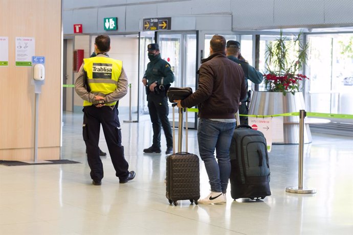 Archivo - Agentes de la Guardia Civil y empleados de seguridad vigilan a los pasajeros en el interior del Aeropuerto de Ibiza.