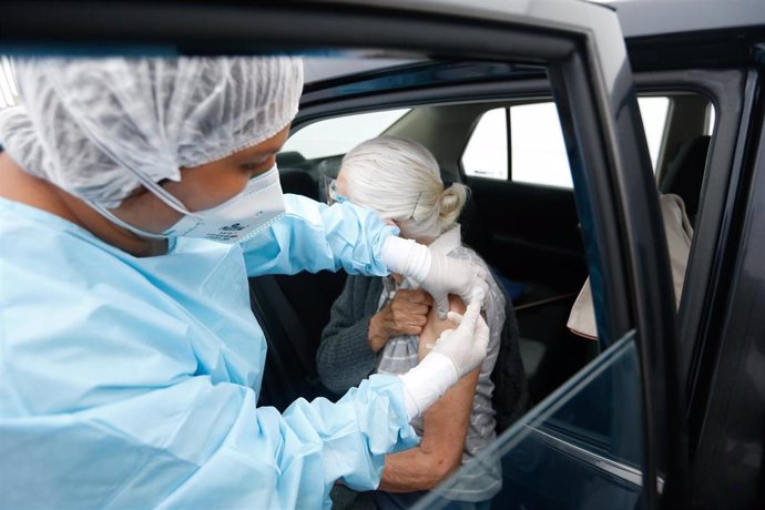 HANDOUT - 23 April 2021, Peru, Lima: An elderly woman in a car is administered a Corona vaccine. Photo: Karel Navarro/Peru's Ministry of Health/dpa - ACHTUNG: Nur zur redaktionellen Verwendung und nur mit vollstndiger Nennung des vorstehenden Credits