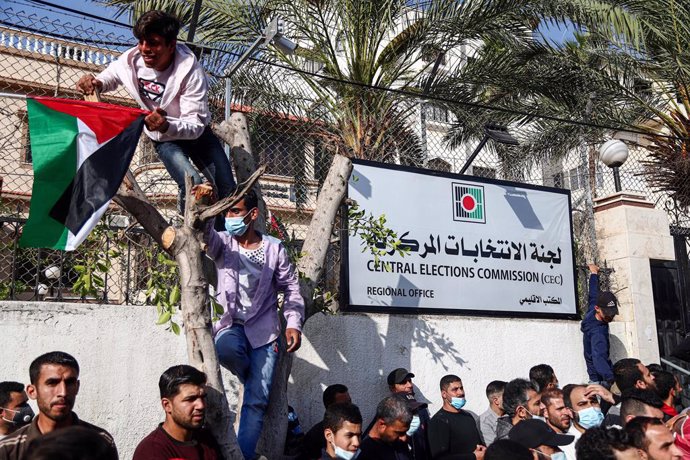 29 April 2021, Palestinian Territories, Gaza: Supporters of exiled former Fatah security chief, Mohammed Dahlan, demonstrate outside the Palestinian Central Elections Commission headquarters against the possibility of cancelling the Palestinian election