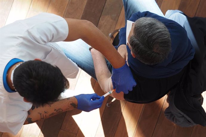 Un trabajador sanitario suministra la vacuna contra el Covid-19 a una persona, en el Centro Cultural Miguel Delibes de Valladolid.