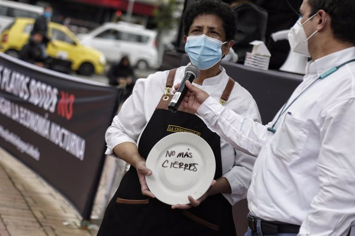 26 April 2021, Colombia, Bogota: A woman holds a plate with words reads "No more closures", during a protest by restaurant and bar workers to demand support for the sector during the Coronavirus pandemic. Photo: Álvaro Tavera/colprensa/dpa