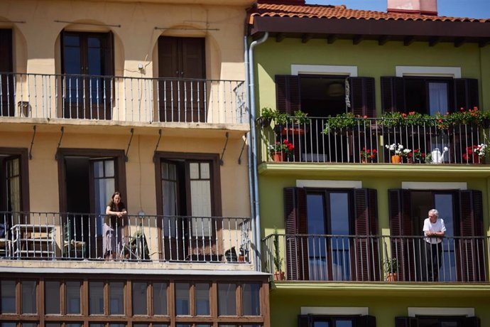 Archivo - Varias personas se asoman a sus balcones en Pamplona.