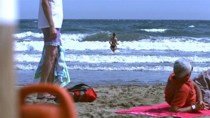 Archivo - Una mujer entra en el agua con mal estado del mar