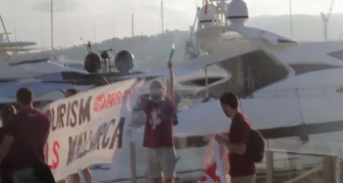 Archivo - Fotograma del vídeo de la protesta de Arran en el puerto, en el que se ve a varios de sus miembros encendiendo bengalas y desplegando pancartas en la zona del Moll Vell de Palma, para manifestarse en contra del turismo de masas.