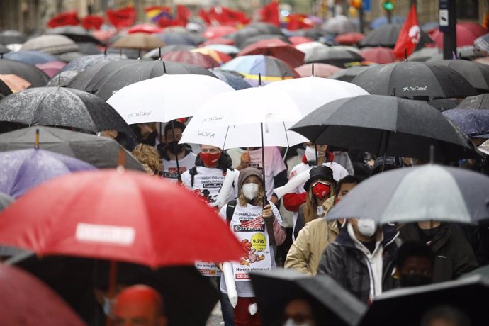 Manifestantes con mascarillas y paraguas en la concentración de Barcelona este 1 de Mayo de 2021